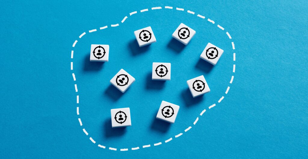 Weiße Würfel mit Personen- und Zielscheiben-Icons gruppiert in einem gestrichelten Kreis - Insight zum Psychometric Marketing