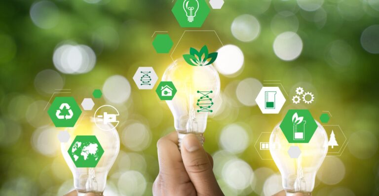 Hand hält leuchtende Glühbirnen umgeben von grünen Nachhaltigkeits-Icons - Erfolgs-Projekt in der Chemiebranche bei mpcg